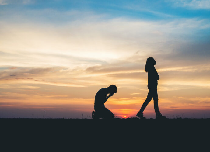 man on knees and woman walking away break up