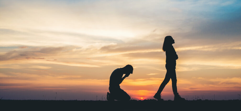 man on knees and woman walking away break up